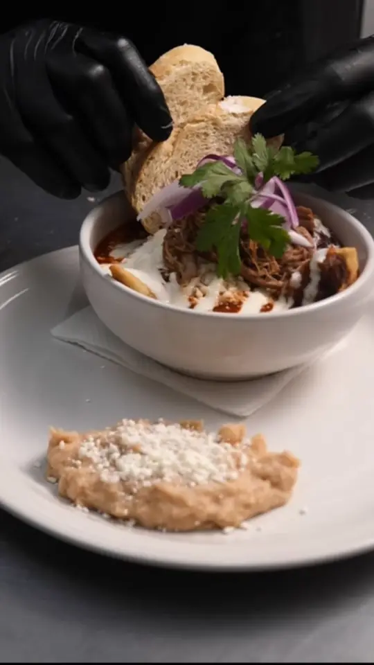 Plato emplatado por un chef con guantes negros