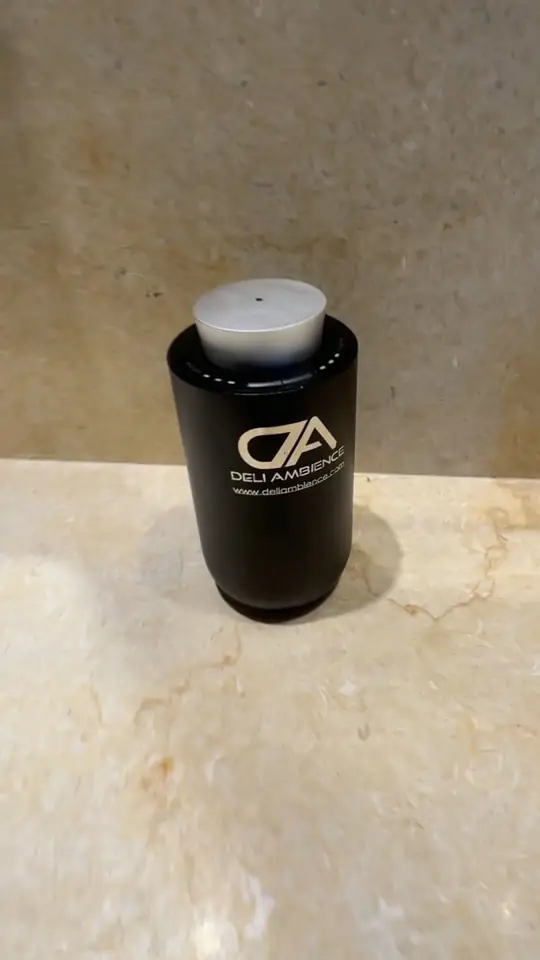 Producto cilíndrico negro sobre una superficie de mármol